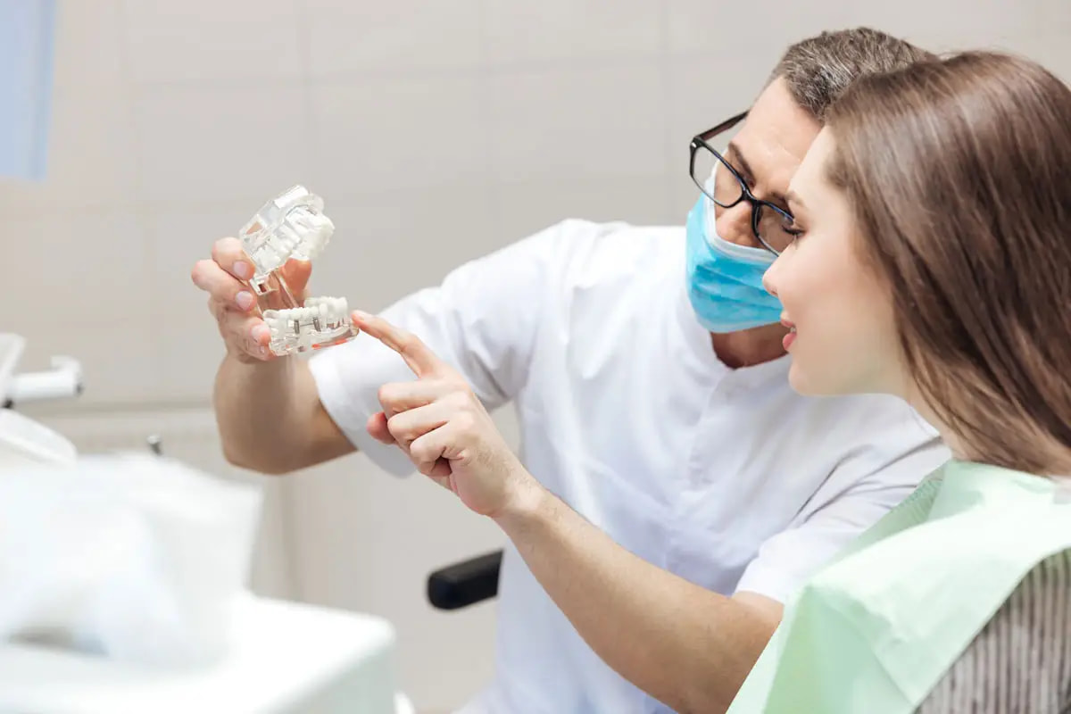 a dental technician holding a model for teeth implants